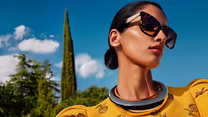 Mujer con gafas de sol Carolina Herrera de la colección Spring 26 bajo un cielo azul